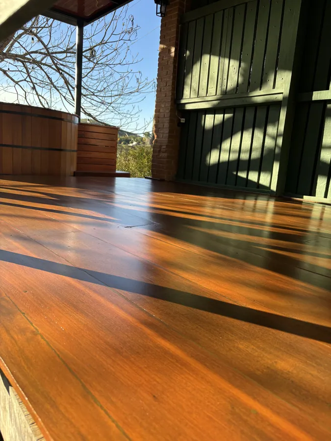 Deck externo de varanda com ofurô, madeira recuperada e envernizada