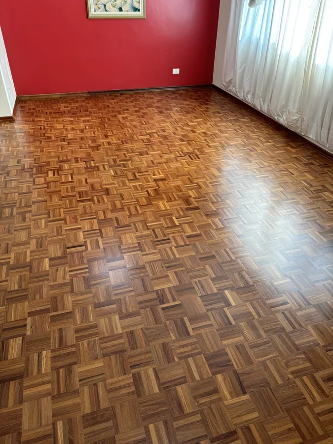 Piso de taco restaurado em sala ampla, com brilho uniforme